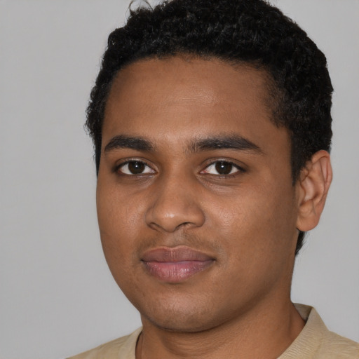 Joyful black young-adult male with short  black hair and brown eyes
