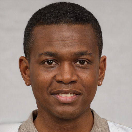 Joyful black young-adult male with short  brown hair and brown eyes