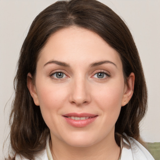 Joyful white young-adult female with medium  brown hair and grey eyes