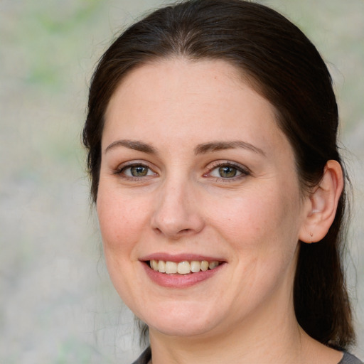 Joyful white adult female with medium  brown hair and green eyes