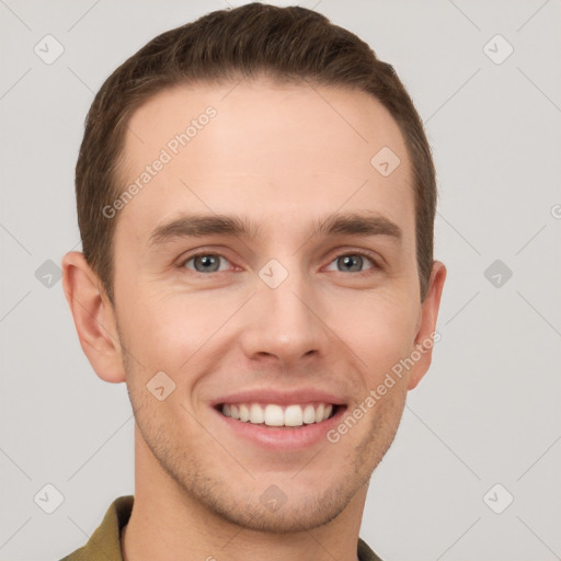 Joyful white young-adult male with short  brown hair and grey eyes