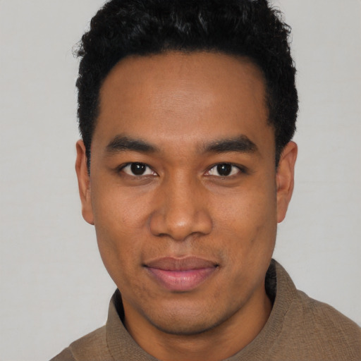 Joyful black young-adult male with short  black hair and brown eyes