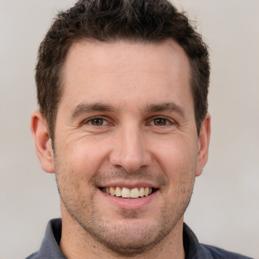 Joyful white adult male with short  brown hair and brown eyes