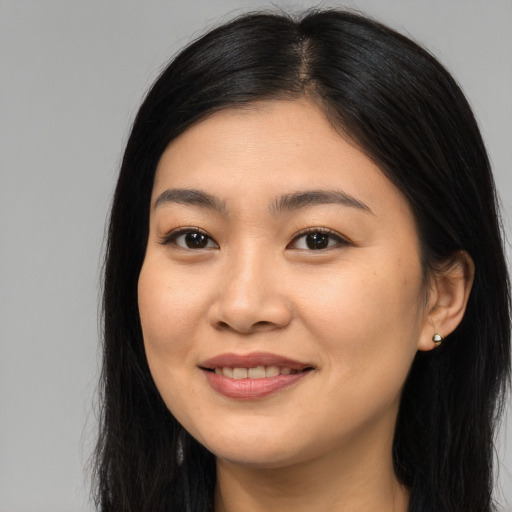 Joyful asian young-adult female with long  brown hair and brown eyes