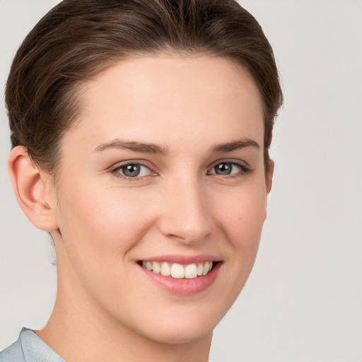 Joyful white young-adult female with short  brown hair and grey eyes