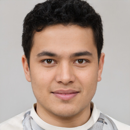 Joyful latino young-adult male with short  brown hair and brown eyes