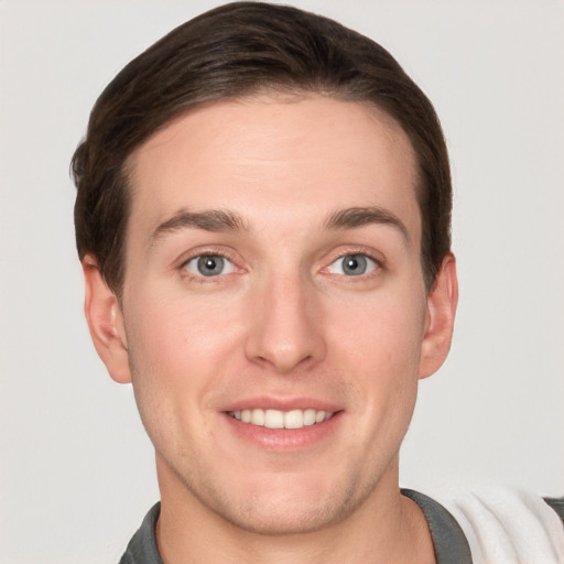 Joyful white young-adult male with short  brown hair and grey eyes