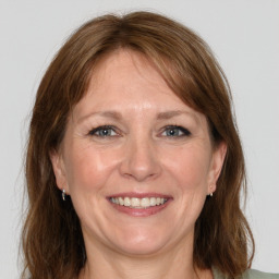 Joyful white adult female with medium  brown hair and grey eyes