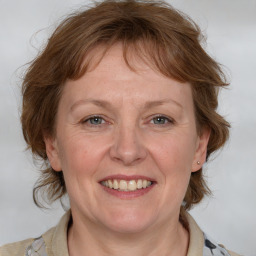 Joyful white adult female with medium  brown hair and blue eyes