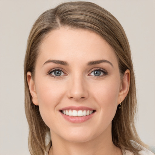 Joyful white young-adult female with long  brown hair and grey eyes