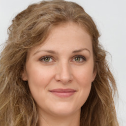 Joyful white young-adult female with long  brown hair and green eyes