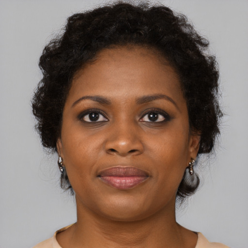 Joyful black young-adult female with long  brown hair and brown eyes
