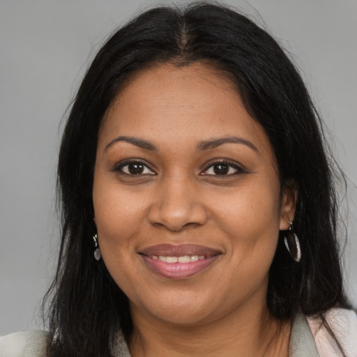 Joyful black young-adult female with long  brown hair and brown eyes