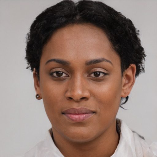 Joyful black young-adult female with short  black hair and brown eyes