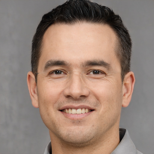 Joyful white young-adult male with short  brown hair and brown eyes