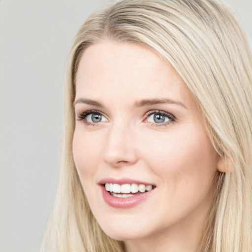 Joyful white young-adult female with long  brown hair and blue eyes