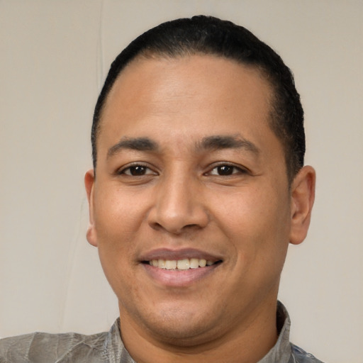 Joyful latino young-adult male with short  black hair and brown eyes