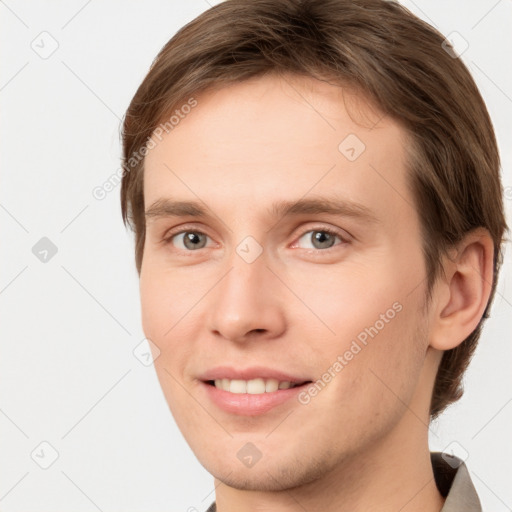 Joyful white young-adult male with short  brown hair and grey eyes