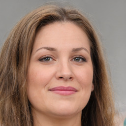 Joyful white young-adult female with long  brown hair and green eyes