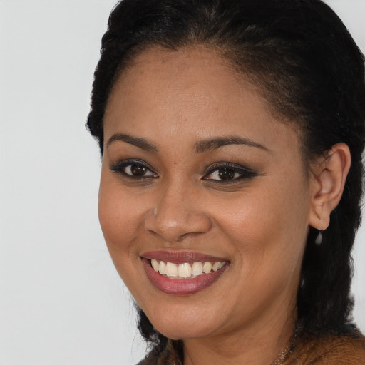 Joyful black young-adult female with long  brown hair and brown eyes