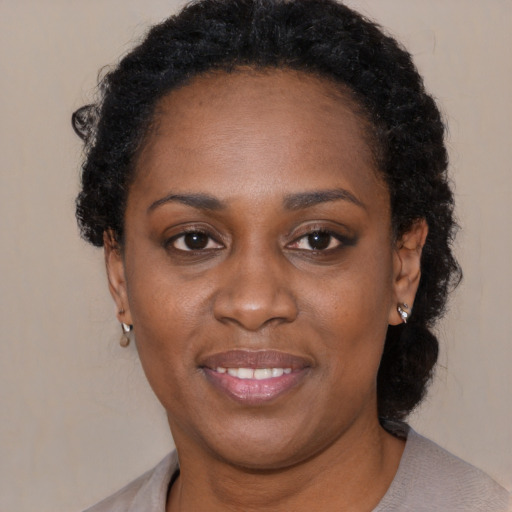 Joyful black adult female with short  brown hair and brown eyes