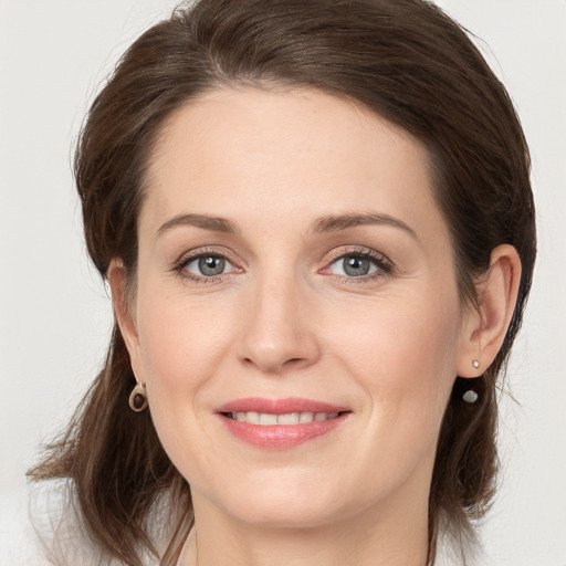 Joyful white young-adult female with long  brown hair and grey eyes