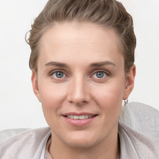 Joyful white young-adult female with short  brown hair and grey eyes