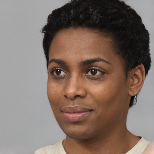 Joyful black young-adult female with short  black hair and brown eyes