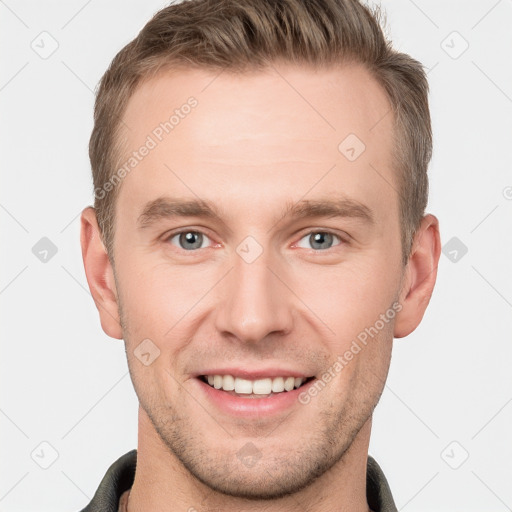 Joyful white young-adult male with short  brown hair and grey eyes