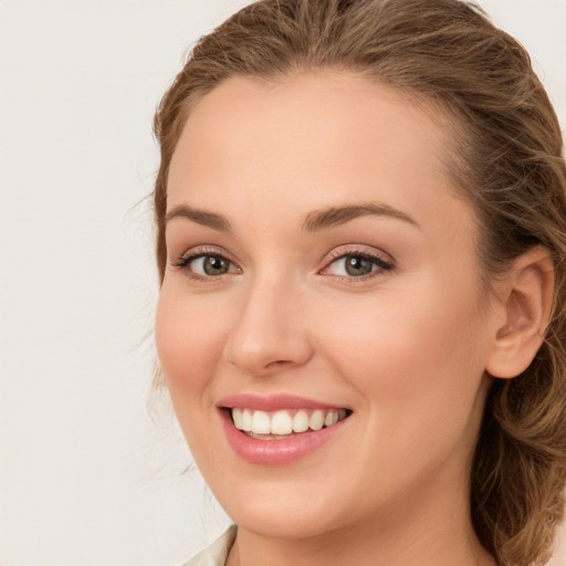 Joyful white young-adult female with long  brown hair and green eyes