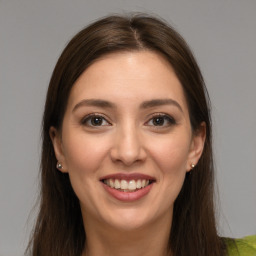 Joyful white young-adult female with long  brown hair and brown eyes