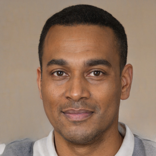 Joyful black young-adult male with short  black hair and brown eyes