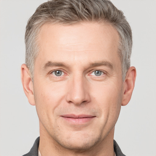 Joyful white adult male with short  brown hair and grey eyes