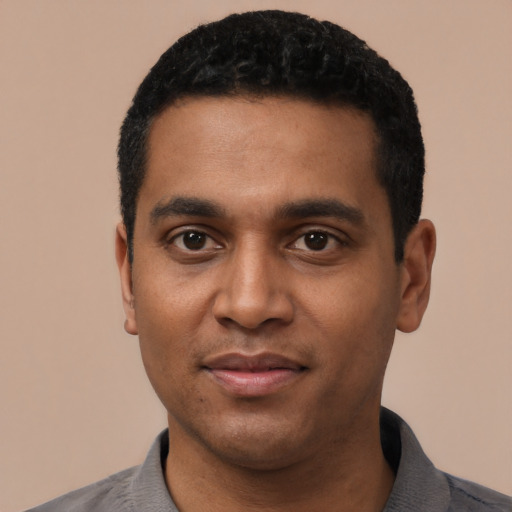 Joyful black young-adult male with short  black hair and brown eyes