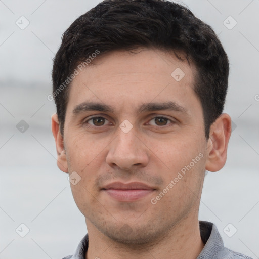 Joyful white young-adult male with short  black hair and brown eyes