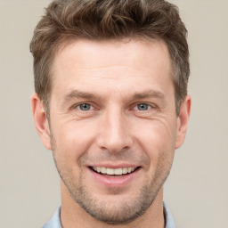 Joyful white adult male with short  brown hair and grey eyes