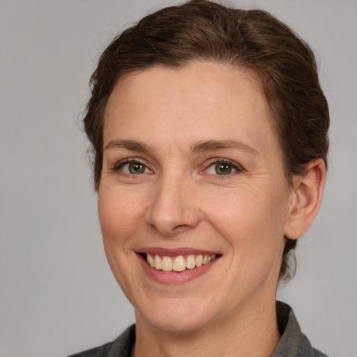 Joyful white adult female with medium  brown hair and grey eyes