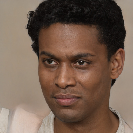 Joyful black young-adult male with short  brown hair and brown eyes