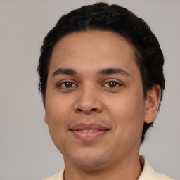 Joyful latino young-adult male with short  black hair and brown eyes