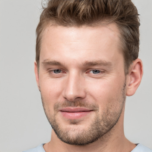 Joyful white young-adult male with short  brown hair and grey eyes