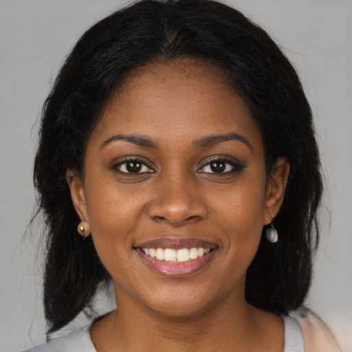 Joyful black young-adult female with medium  black hair and brown eyes