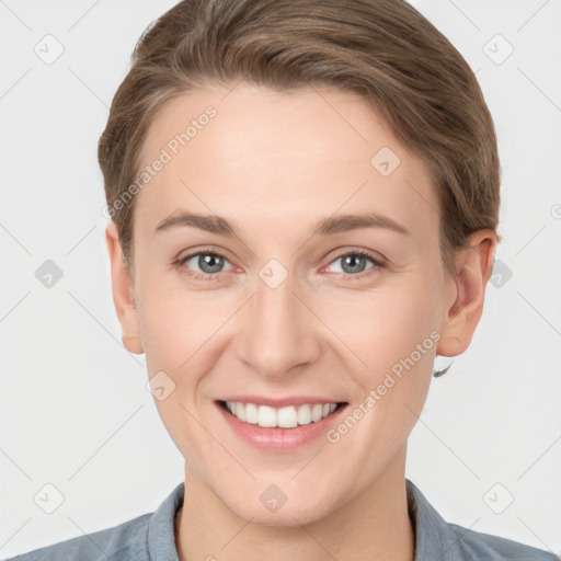 Joyful white young-adult female with short  brown hair and grey eyes