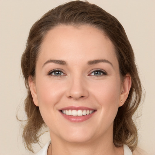 Joyful white young-adult female with medium  brown hair and green eyes