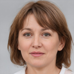 Joyful white adult female with medium  brown hair and grey eyes