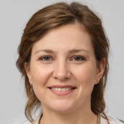 Joyful white adult female with medium  brown hair and grey eyes