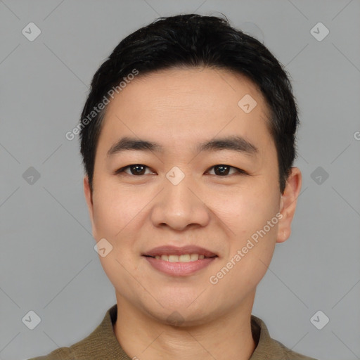 Joyful asian young-adult male with short  black hair and brown eyes