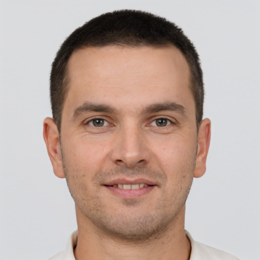 Joyful white young-adult male with short  brown hair and brown eyes