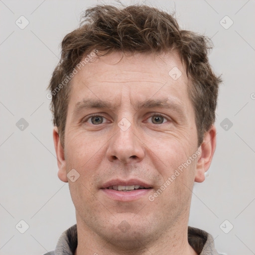 Joyful white adult male with short  brown hair and grey eyes