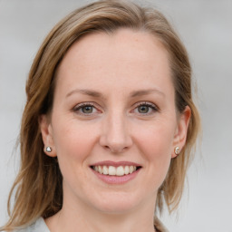 Joyful white young-adult female with medium  brown hair and blue eyes