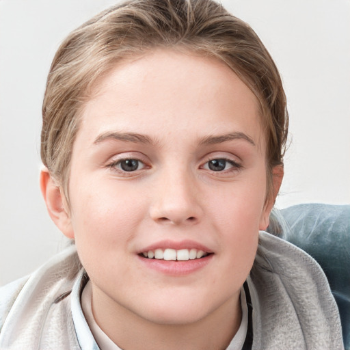 Joyful white child female with short  brown hair and blue eyes